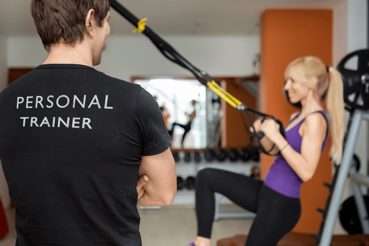 Personal Trainer begleitet eine Kundin beim Training im Studio