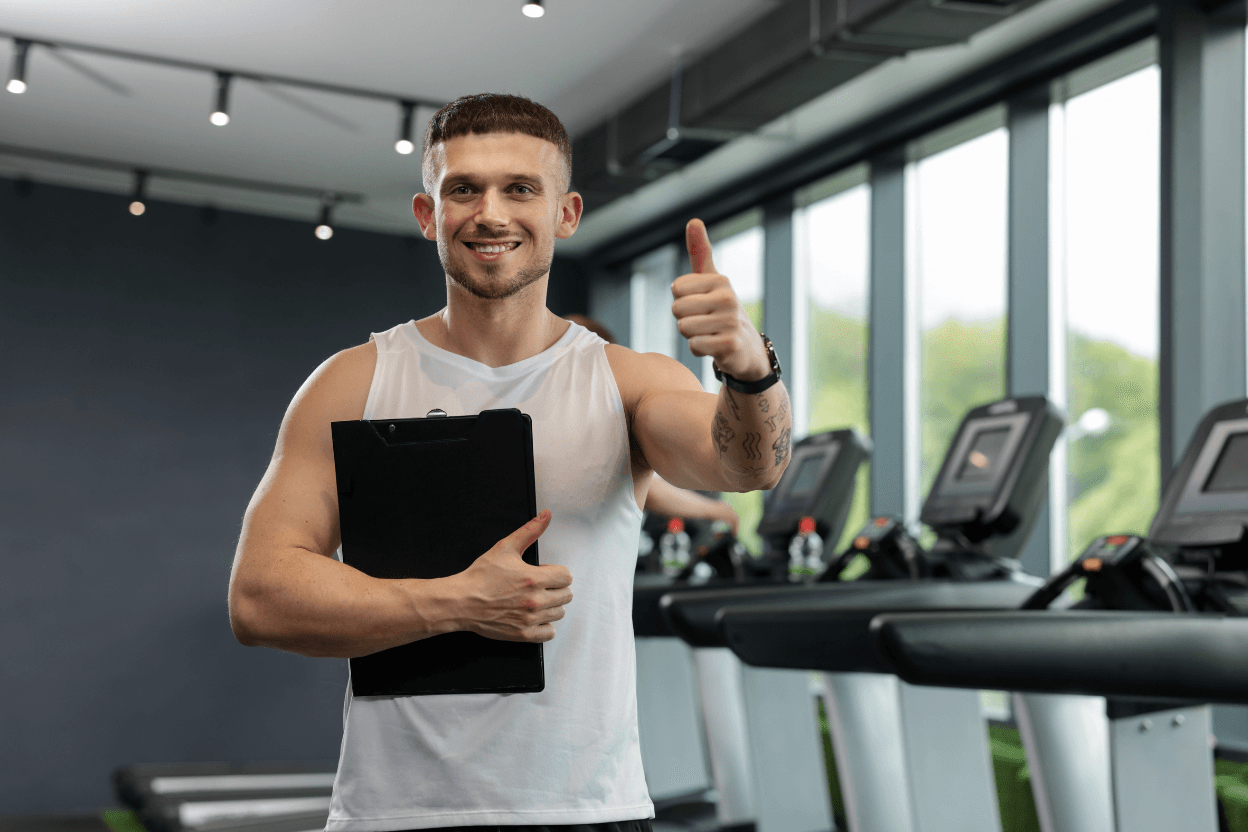 Personal Trainer mit Klemmbrett im Studio